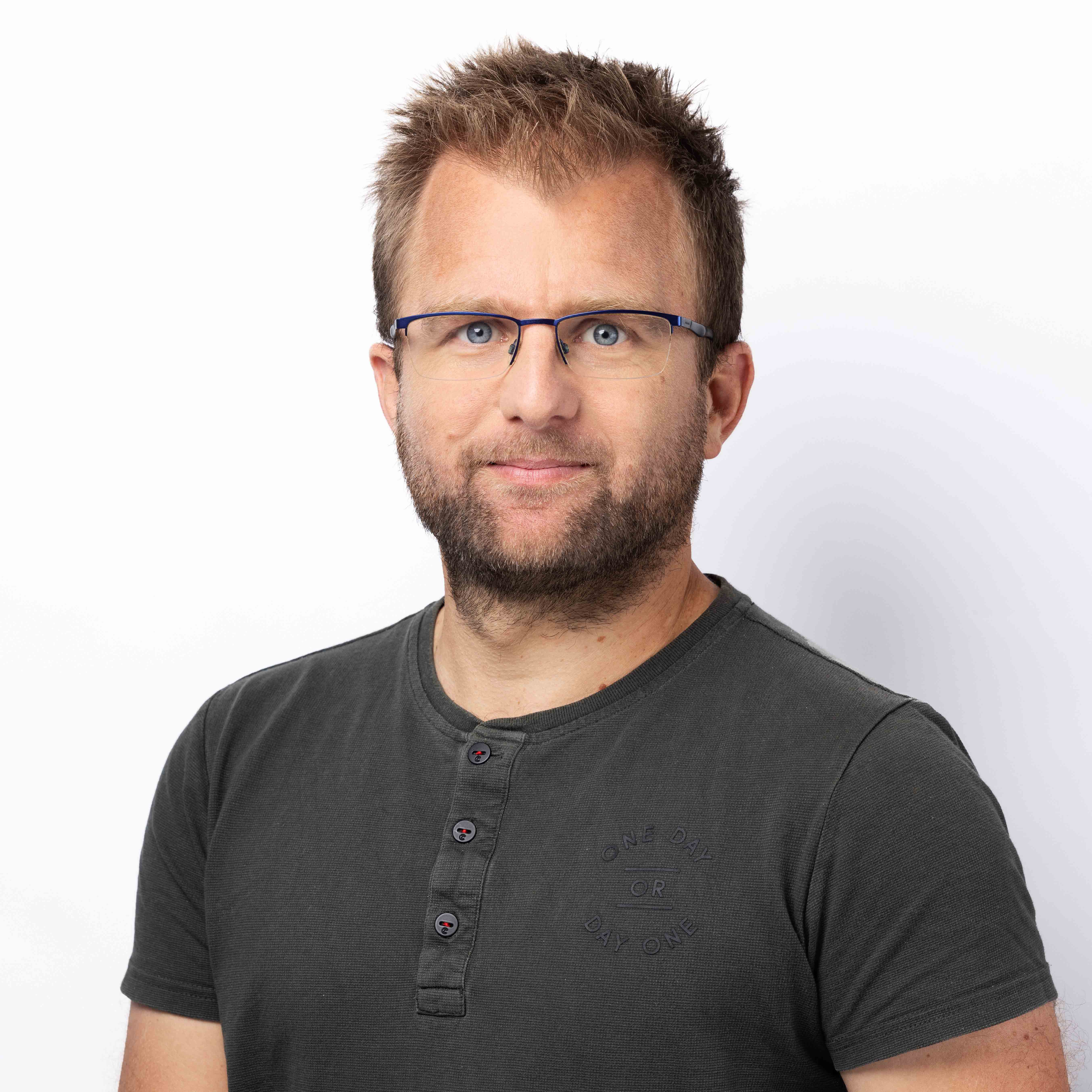 Portrait photo of Freek Pols, wearing glasses and a gray Henley shirt.