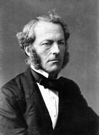 A black-and-white portrait photo of George Stokes. He is wearing a suit with a bowtie. He has a stern facial expression and prominent sideburns. 