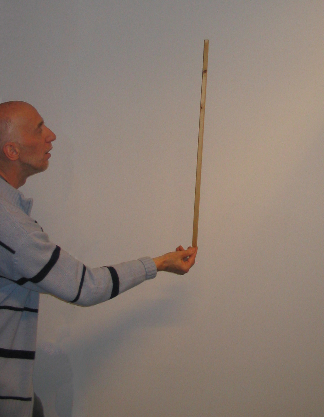 a teacher balancing a stick on his finger