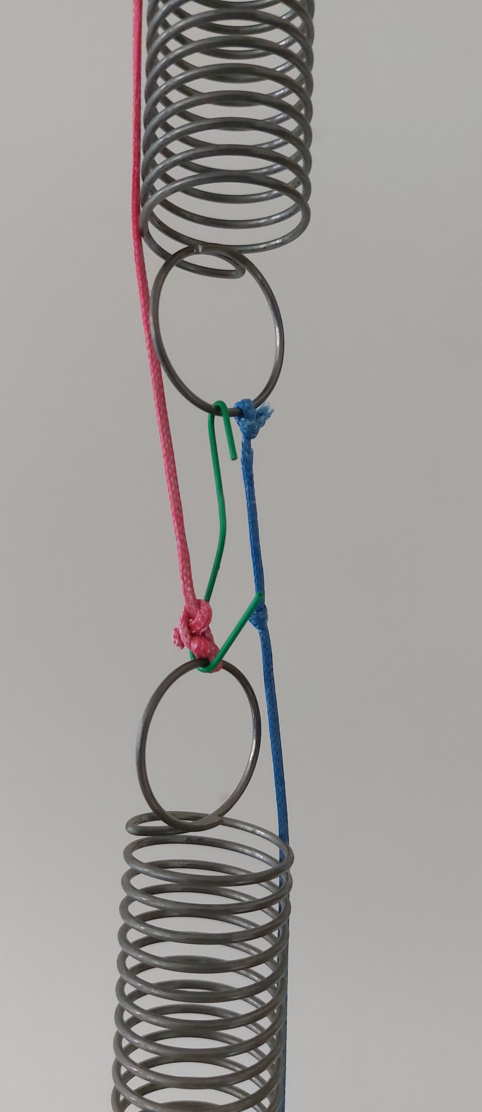 a close up of the hook connecting the springs and wires