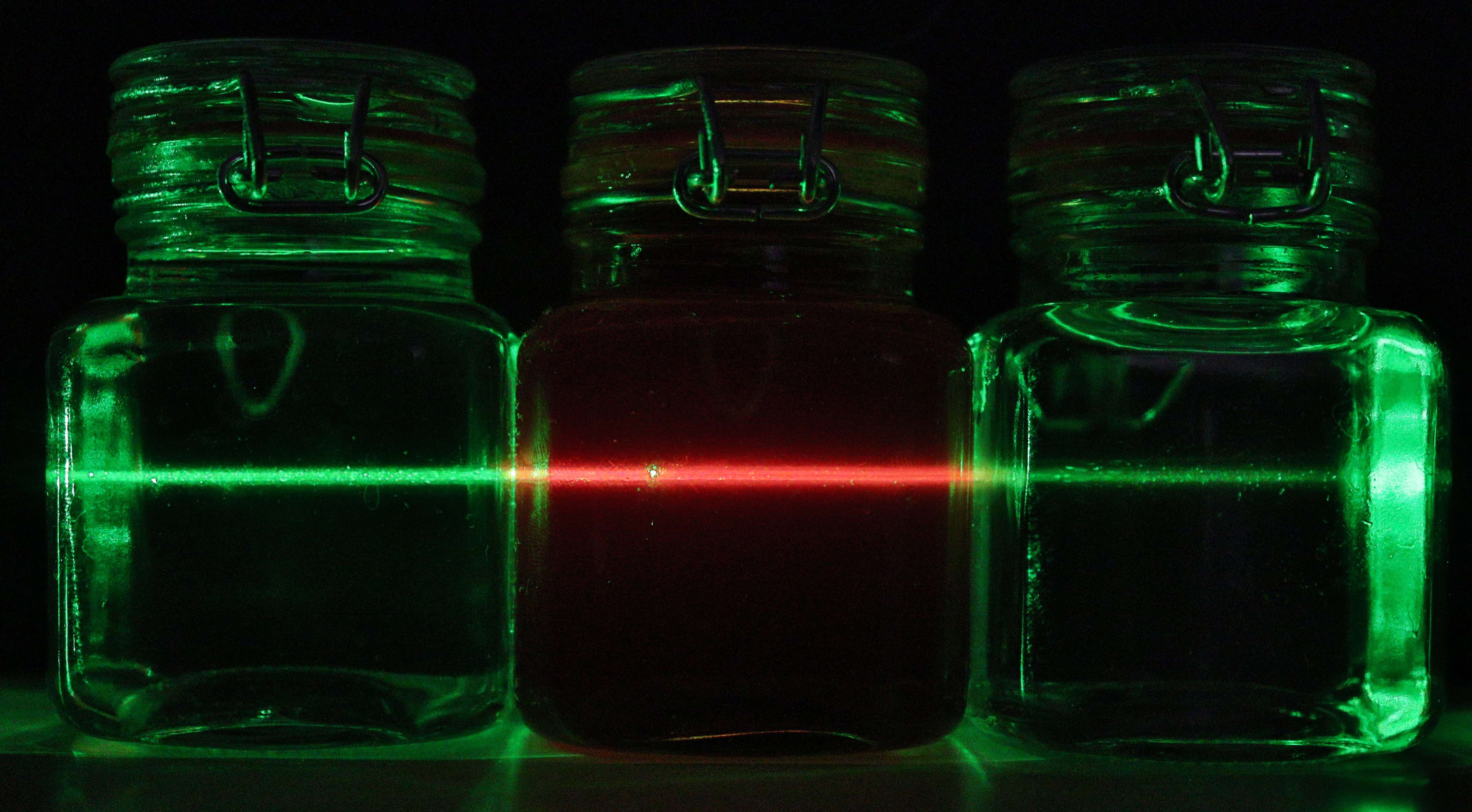 three jars, straight laser beam going from green to red to green again.