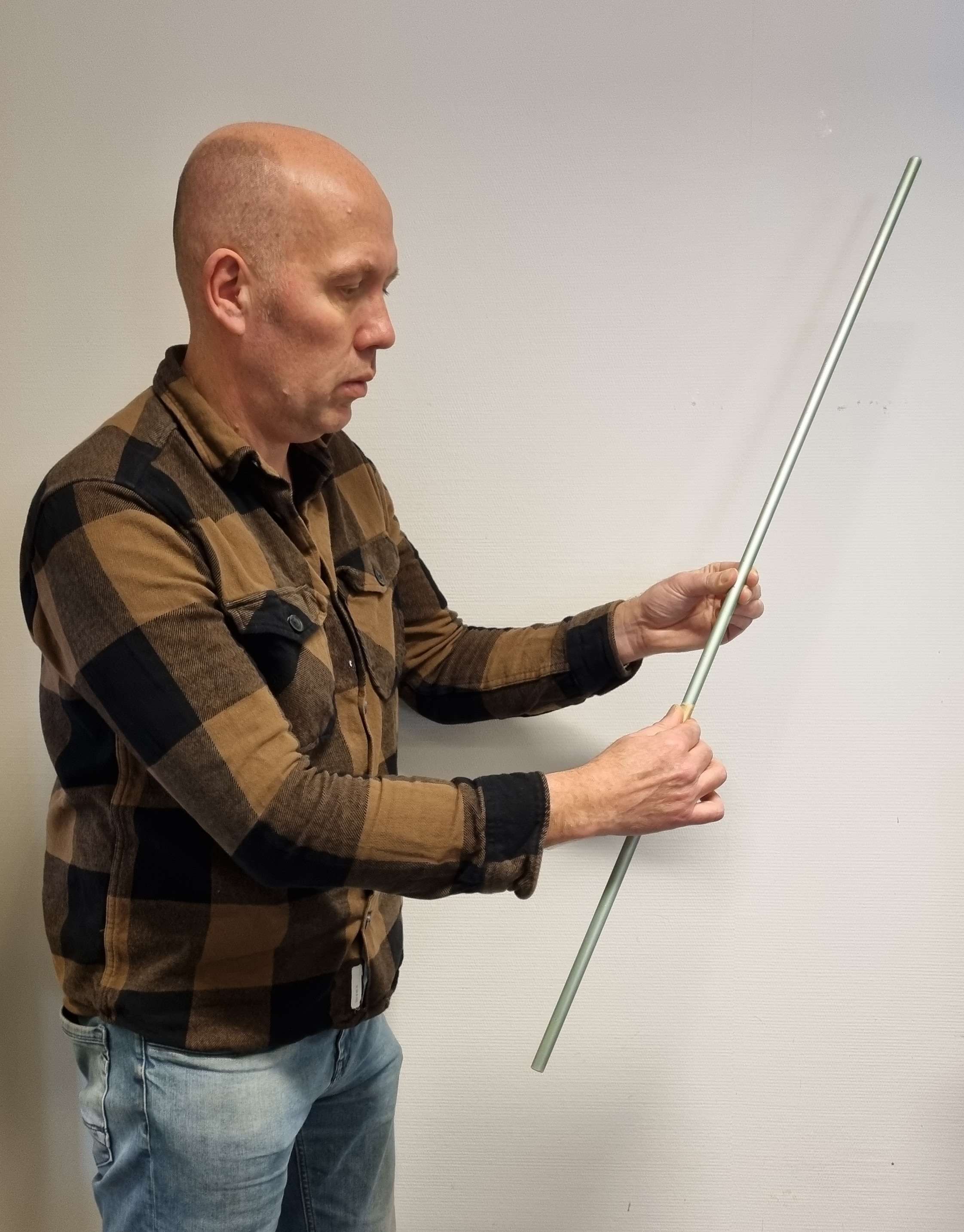 a teacher with a tall rod, moving his fingers along the rod.